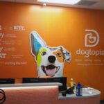 A bright orange wall greets pet owners at the entrance to a Dogtopia built by Tri-North.