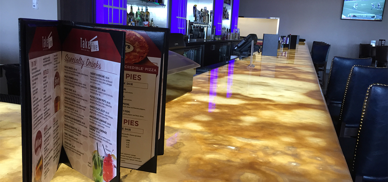 Tri-North Builders project at the Take Five Lounge showing the menu and the entire bar with barstools.