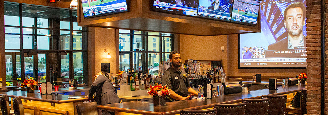 Full bar, bartenders, barstools and television screen in lounge area of the Movie Tavern Brookfield.