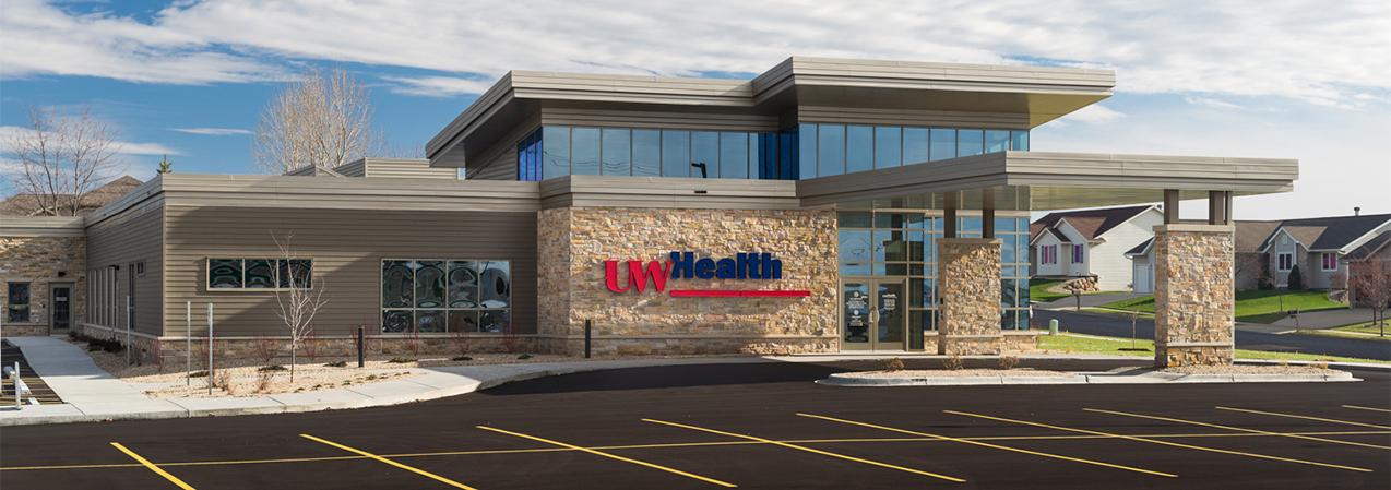 Front of the UW Health Cottage Grove clinic in Cottager Grove, WI, including parking lot and front door as remodeled by Tri-North Builders.