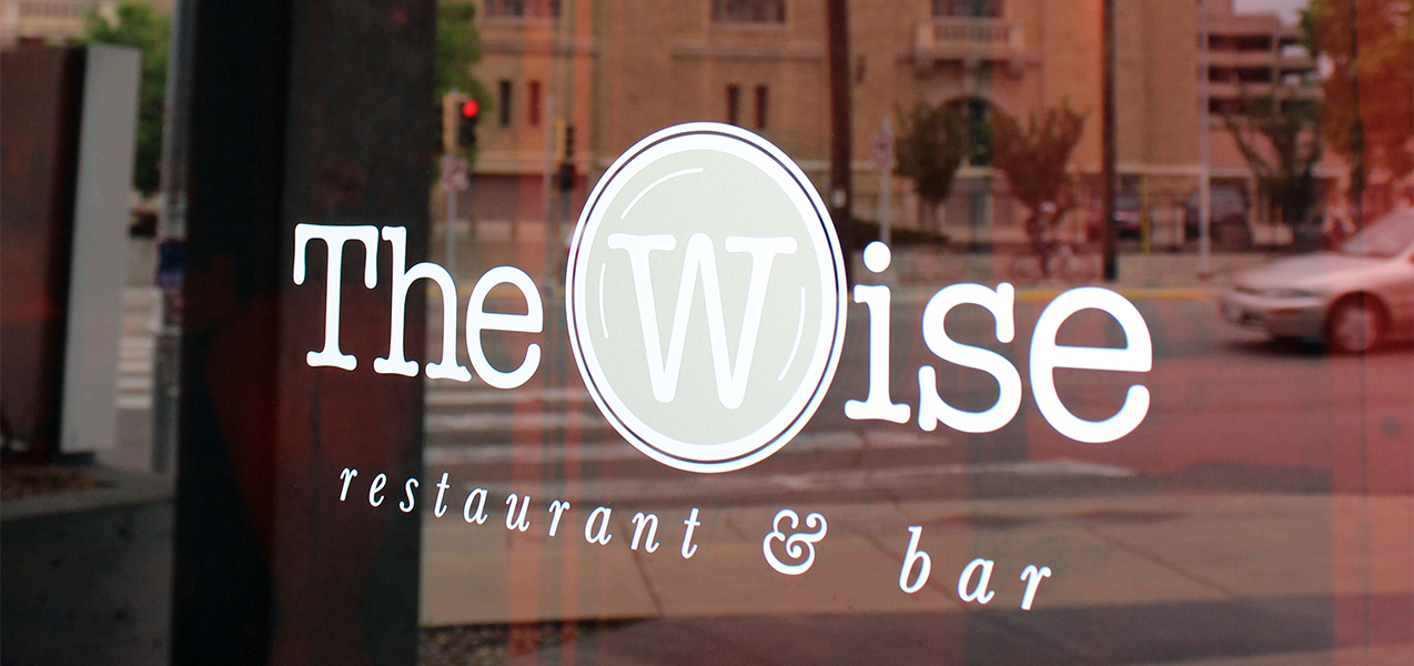 Close up of The Wise at Hotel Red restaurant logo on window in Madison, WI, a Tri-North Builders project.